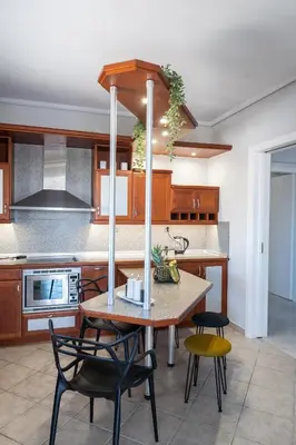 a kitchen with a table and some chairs in it at Luxury Apartment in Glyfada with Sea View in Athens
