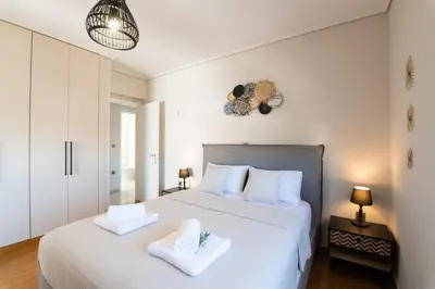 a bedroom with a large white bed with two towels at Luxury Apartment in Glyfada with Sea View in Athens