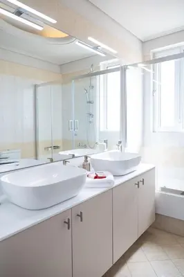 two sinks in a bathroom with two mirrors at Luxury Apartment in Glyfada with Sea View in Athens