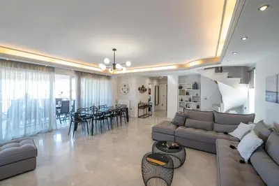 a living room with a couch and a dining room at Luxury Apartment in Glyfada with Sea View in Athens
