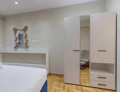 a bedroom with a bed and a mirror on the wall at Voulis Apartment 1 in Athens