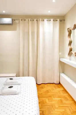 a bedroom with a bed and a curtain at Voulis Apartment 1 in Athens