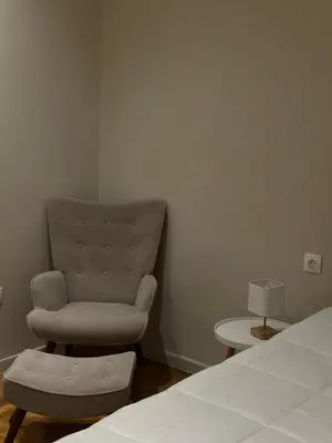 a bedroom with a chair sitting next to a bed at Voulis Apartment 1 in Athens