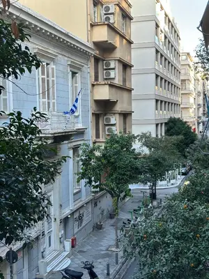 a building with a flag on a balcony on a city street at Voulis Apartment 1 in Athens