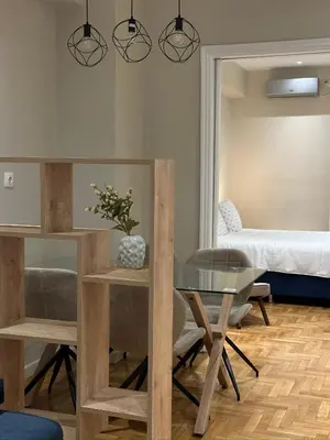 a living room with a table and a bed at Voulis Apartment 1 in Athens