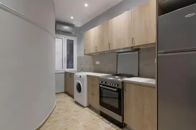 a kitchen with a stove and a washer and dryer at Voulis Apartment 2 in Athens