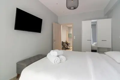 a bedroom with a white bed with towels on it at Voulis Apartment 2 in Athens