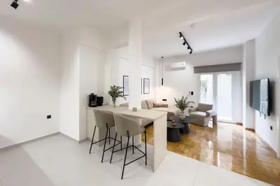 a kitchen and living room with a table and chairs at AtheNeon Deluxe Suite in Athens