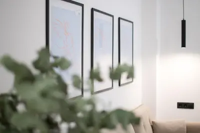 a living room with a couch and framed pictures on the wall at AtheNeon Deluxe Suite in Athens