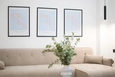 a living room with a couch and a vase with flowers at AtheNeon Deluxe Suite in Athens