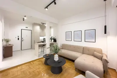 a living room with a couch and a table at AtheNeon Deluxe Suite in Athens