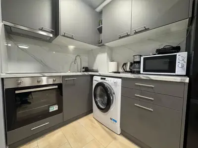 a kitchen with a washing machine and a microwave at Elegant Escapes 8 in Athens