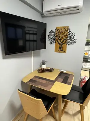 a dining room table and chairs with a television on the wall at Elegant Escapes 8 in Athens