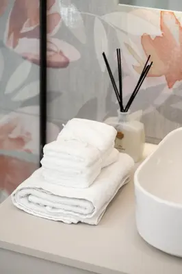 a pile of towels sitting on a counter next to a toilet at Urban Blush Pangrati by Premium Key in Athens