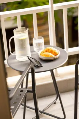 a small table with a plate of food and a drink at Urban Blush Pangrati by Premium Key in Athens