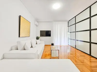 a living room with a white couch and a table at Casa Divas Galaxy Suite in Athens
