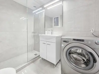 a white bathroom with a washing machine and a shower at Casa Divas Galaxy Suite in Athens