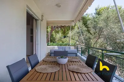 a wooden table and chairs on a balcony at Turquoise Seashell Retreat Family Oasis N Beach in Vari