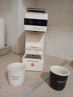 a coffee maker sitting on a counter next to two cups at Mary's vintage house in Athens