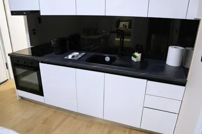 a kitchen with a sink and a black counter top at 2 Bedroom Home Kallithea - Arhontoula Residences in Athens