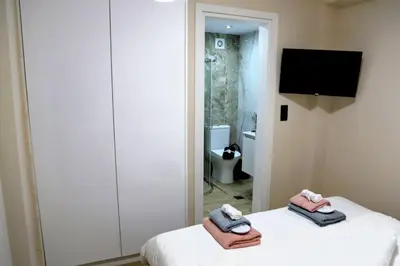 a room with a bed and a tv and a bathroom at 2 Bedroom Home Kallithea - Arhontoula Residences in Athens