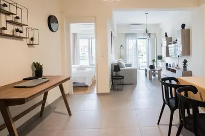 a kitchen and living room with a table and a dining room at ANDIE Kallithea Apartment in Athens