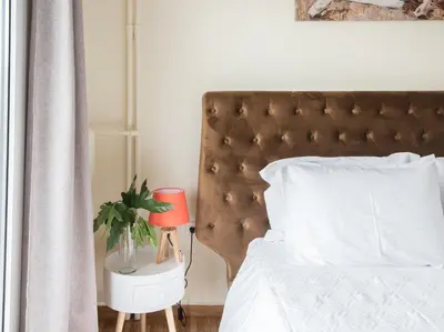 a bedroom with a bed with a red lamp and a plant at ANDIE Kallithea Apartment in Athens