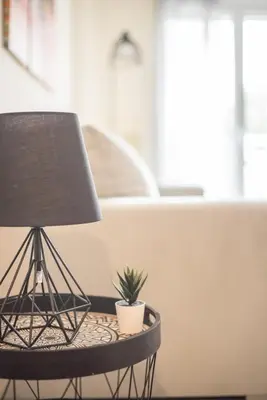 a table with a lamp and a plant on it at ANDIE Kallithea Apartment in Athens