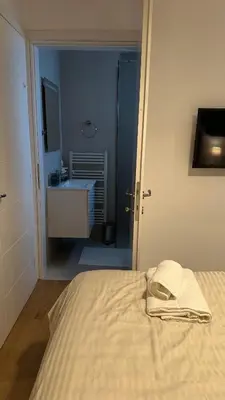 a bedroom with a bed and a sink and a bathroom at A decent stay in center Glyfada in Athens