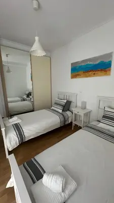 two beds in a room with white walls at A decent stay in center Glyfada in Athens