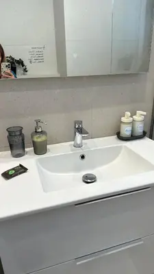 a white sink with two candles and a mirror at A decent stay in center Glyfada in Athens