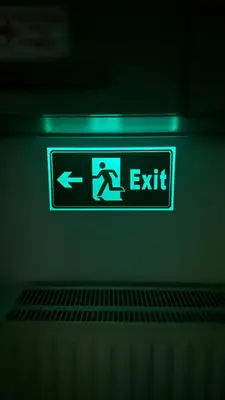 a green exit sign with a person on it at A decent stay in center Glyfada in Athens