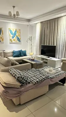 a living room with a couch and a tv at A decent stay in center Glyfada in Athens