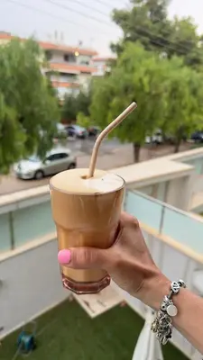 a person holding a drink in a cup at A decent stay in center Glyfada in Athens
