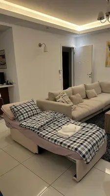 a living room with a couch and a bed at A decent stay in center Glyfada in Athens