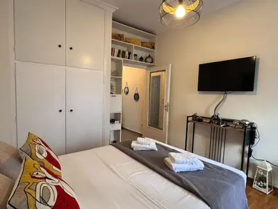a bedroom with a bed and a flat screen tv at Lycabettus Elia in Athens