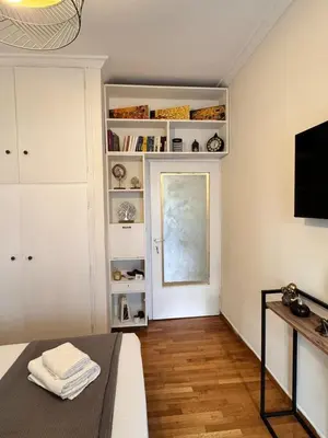 a living room with white shelves and a window at Lycabettus Elia in Athens