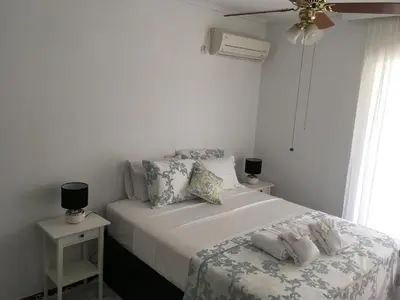 a white bedroom with a bed with towels on it at Amy's residence in Athens