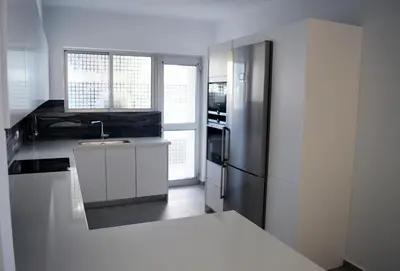 a kitchen with a stainless steel refrigerator and white cabinets at Amy's residence in Athens