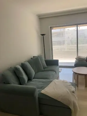a living room with a blue couch and a table at Amy's residence in Athens