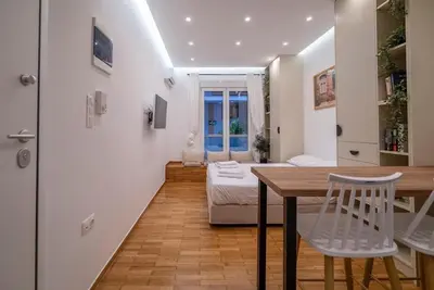 a living room with a table and a bed at The Honeycomb Suite in Athens