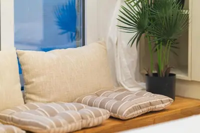 a row of pillows on a table next to a couch at The Honeycomb Suite in Athens