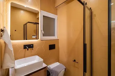 a bathroom with a sink and a toilet and a mirror at The Honeycomb Suite in Athens