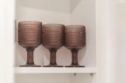 four brown wine glasses sitting on a shelf at The Honeycomb Suite in Athens