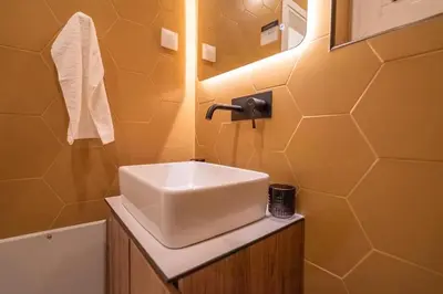 a bathroom with a white sink and a mirror at The Honeycomb Suite in Athens