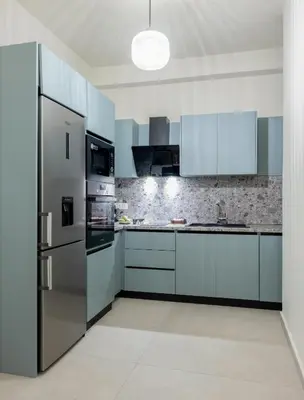a kitchen with stainless steel appliances and blue cabinets at Urban Terra Pangrati by Premium Key in Athens
