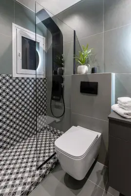 a bathroom with a toilet and a glass shower at Urban Terra Pangrati by Premium Key in Athens
