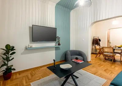 a living room with a table and a tv on a wall at Urban Terra Pangrati by Premium Key in Athens