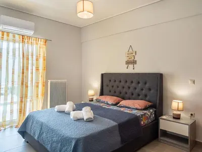 a bedroom with a bed with towels on it at Athens Airport Luxury Apartment in Spáta