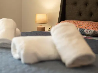 a group of four white socks on a bed at Athens Airport Luxury Apartment in Spáta